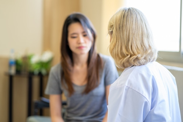 Psiquiatra profesional escuchando a su paciente en la clínica médica o el servicio de salud mental del hospital