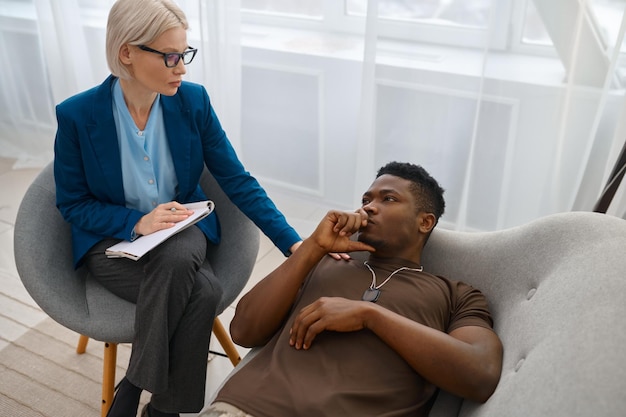 Psychologe unterstützt depressiven männlichen Soldaten, der ihm die Hand auf die Schulter legt. PTBS-Behandlung