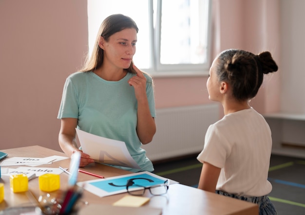 Foto psychologin, die einem mädchen in der sprachtherapie hilft