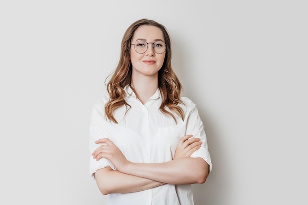 Psychologin in einem weißen Hemd mit Brille auf weißem Hintergrund im Studio