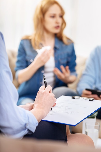 Foto psychologische diagnose. nahaufnahme von notizen einer erfolgreichen professionellen psychologin, die während der psychologischen sitzung mit ihren klienten gemacht wird