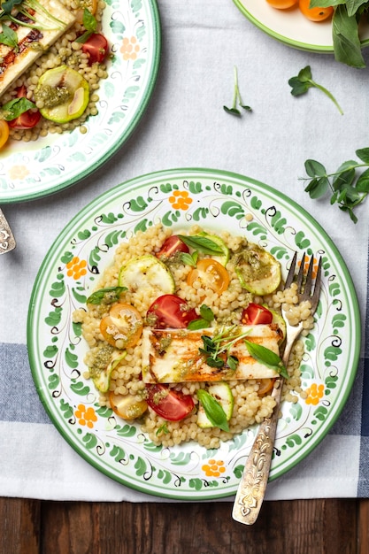 Ptitim o cuscús de pasta israelí con tomates y calabacín, halloumi