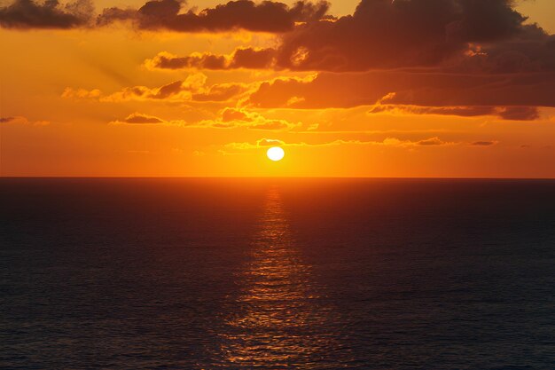 Foto publicar una vista aérea del cielo dorado del atardecer sobre el mar