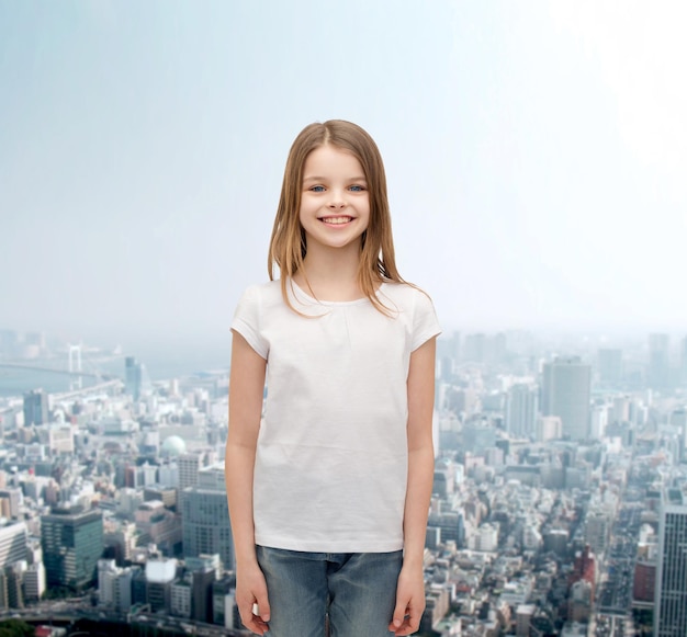 publicidad y concepto de diseño de camisetas - niña sonriente con camiseta blanca sobre fondo blanco