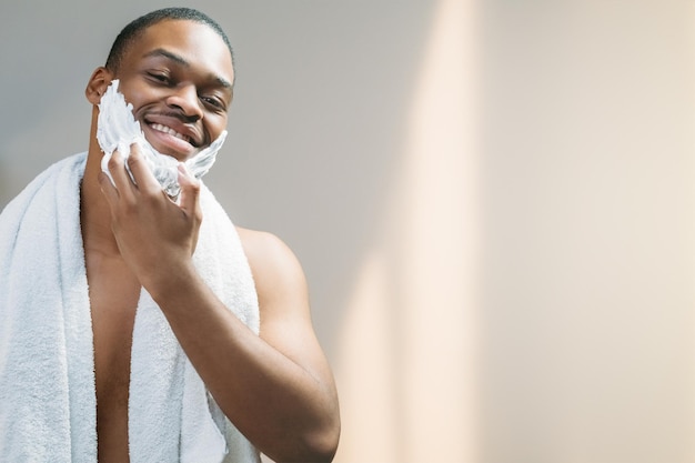 Publicidad de productos cosméticos para el cuidado de la piel masculina aseo higiene feliz hombre africano sin camisa con t blanca