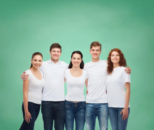 publicidade, amizade, educação, escola e conceito de pessoas - grupo de adolescentes sorridentes em camisetas brancas em branco sobre fundo de placa verde