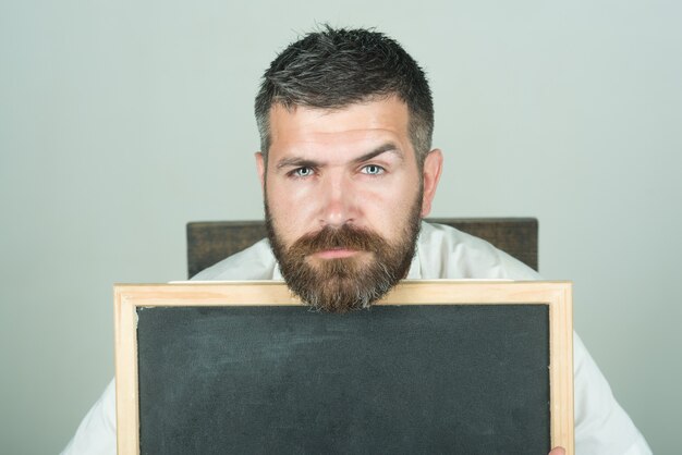 Publicidade ou conceito de negócio homem atraente com barba e bigode olhando por trás do preto