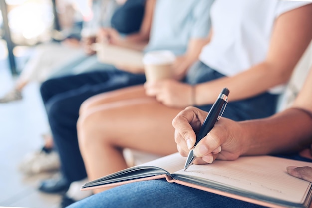 Foto publikum schreibt notizen und notizbuch zum erlernen von wissen bei konferenztreffen oder workshops für aus- und weiterbildung im kongressraum nahaufnahme von frauenhänden und -zielen mit einer gruppe von menschen