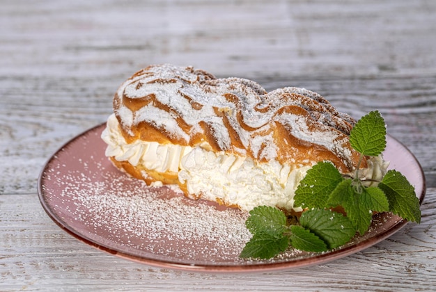 Puddingkuchen mit Sahne auf einem hellen Holztisch