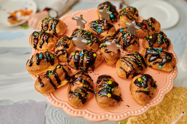 Puddingkuchen mit Schokoladenfondant auf einem Tablett auf einem festlich gedeckten Tisch mit Leckereien und Getränken