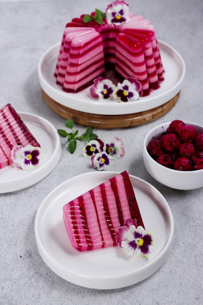 Pudim buah naga Pudim em camadas feito de fruta do dragão e leite decorado com flores comestíveis