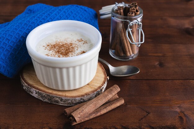 Pudim cremoso de arroz e canela em uma base de madeira. conceito de pastelaria.