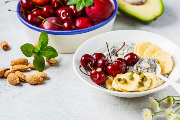 Pudim de Chia com banana, cereja e nozes em chapa branca.