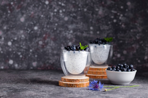 Pudim de Chia com hortelã e mirtilos em copos em um carrinho de madeira