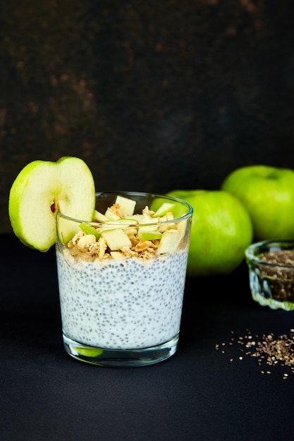 Pudim de chia saudável com maçãs e granola em vidro.