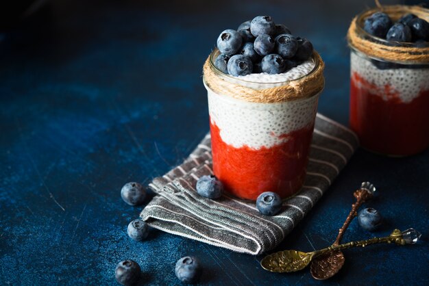 Pudim de chia vegan com leite de coco e purê de morango em uma jarra