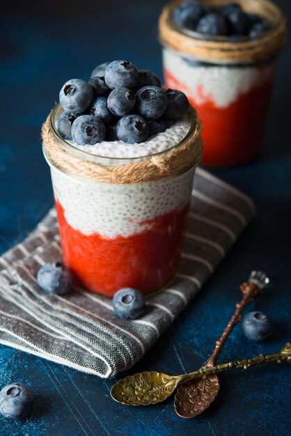 Pudim de chia vegan com leite de coco e purê de morango em uma jarra