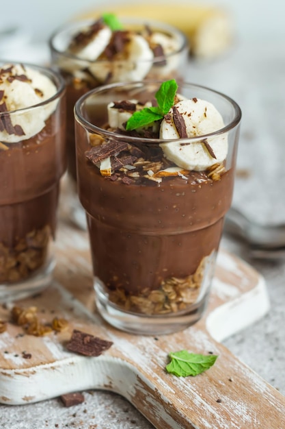 Pudim de chocolate com chia e banana em copos. Sobremesa ou café da manhã saudável.