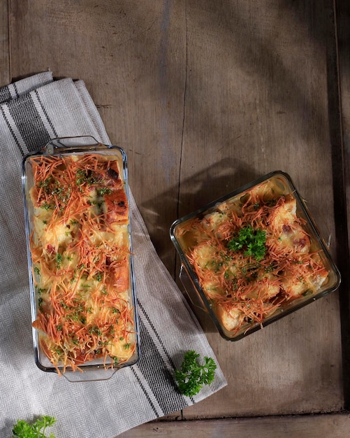 Pudim de pão salgado caseiro com linguiça e queijo cheddar ralado, servido em assadeira transparente