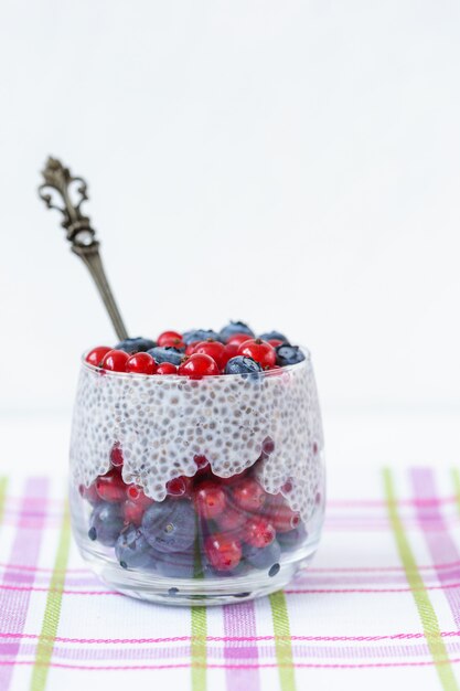 Pudim de sementes de chia com mirtilos e bagas de groselha em um copo