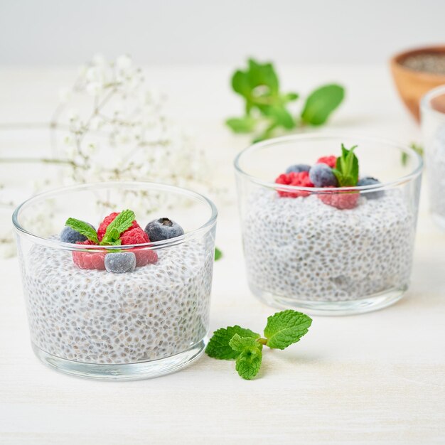 Foto pudín de chía con bayas frescas frambuesas arándanos dos vasos