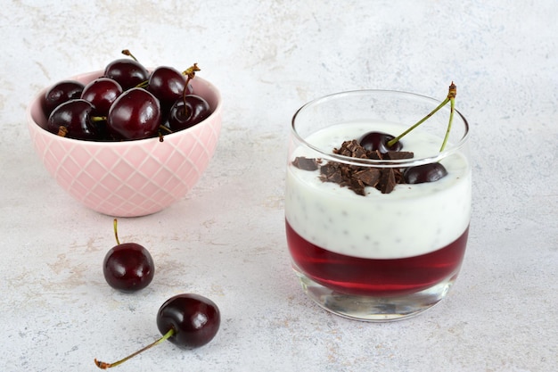 pudín de chía con gelatina de cereza y chocolate en vaso y tazón de cerezas