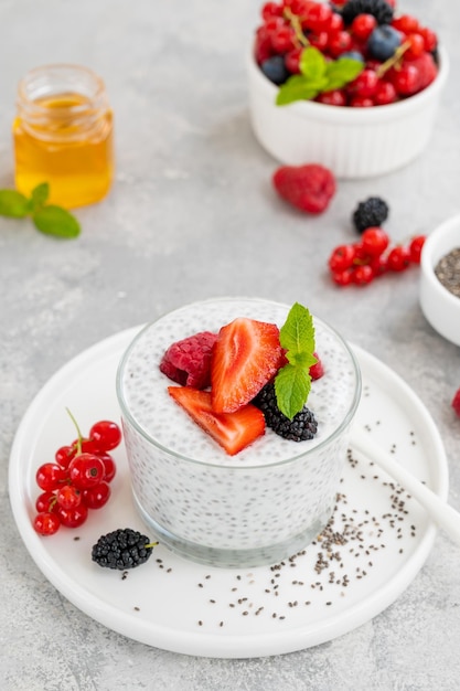 Pudín de chía de vainilla con bayas frescas y miel en un vaso Concepto de superalimentos Espacio de copia