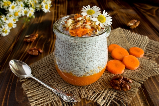 Pudín con chía, zanahoria y nueces sobre el fondo de madera rústica