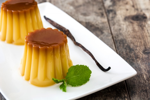 Pudin de huevo con caramelo en la mesa de madera