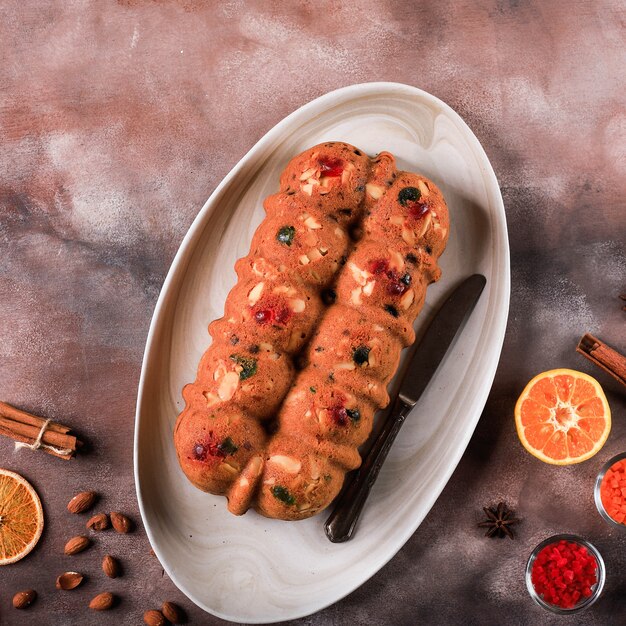 Pudín de pastel de frutas secas de Navidad con ron casero para fiesta familiar. Servido en una mesa de cemento marrón con Sunkist seco