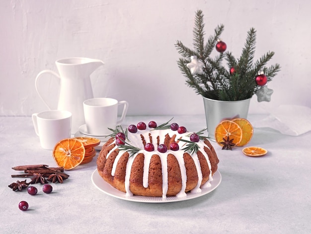 Pudín de pastel de Navidad en un plato blanco con naranjas secas y tazas de café en la copia de fondo