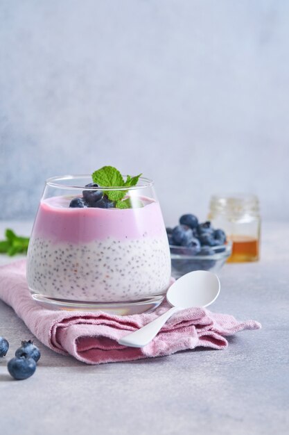 Pudín de semillas de chía con yogur de arándanos y bayas frescas en vaso preparado para un desayuno saludable. Enfoque selectivo