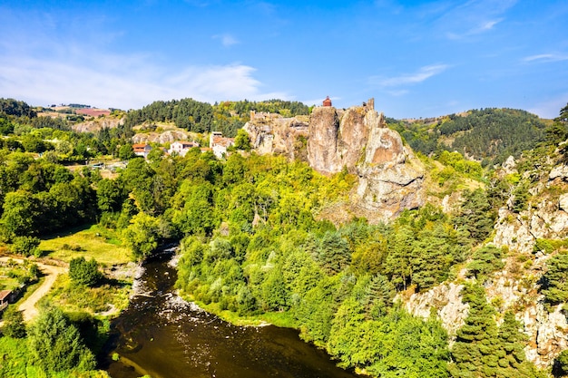 Pueblo de Arlempdes con su castillo en la cima de una roca de basalto en un meandro de la alta montaña del río Loira