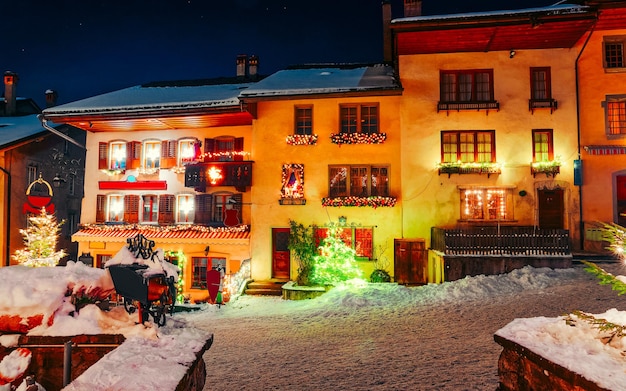 Pueblo de la ciudad de Navidad Gruyeres en Suiza. Gruyere en Friburgo durante el invierno. Nieve en la noche. Castillo cerca de Charmey en la calle Europa. Vacaciones. Edificios famosos. Tradición suiza en navidad o año nuevo