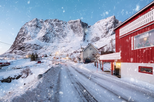 Pueblo escandinavo con nieve y montaña nevada en Lofoten