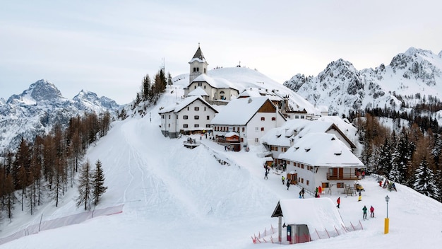Pueblo idílico en la cima de la colina en invierno. Estación de esquí, esquí, turismo. Monte Lussari, Italia.