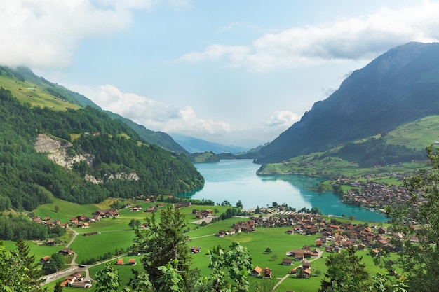 Un pueblo junto al lago en el fondo de las montañas alpinas