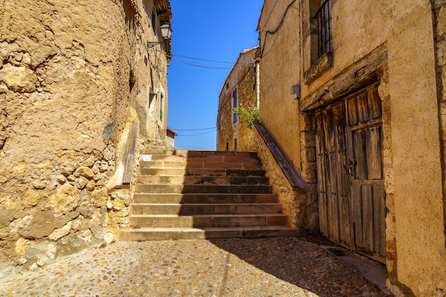 Pueblo medieval con casas de piedra, calles empedradas, puertas y ventanas antiguas, arcos y murallas. Maderuelo Segovia España.