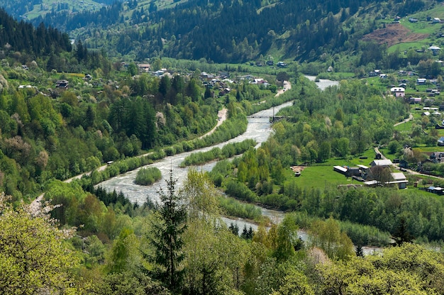 Pueblo de montaña junto al río en las montañas de los Cárpatos, Ucrania