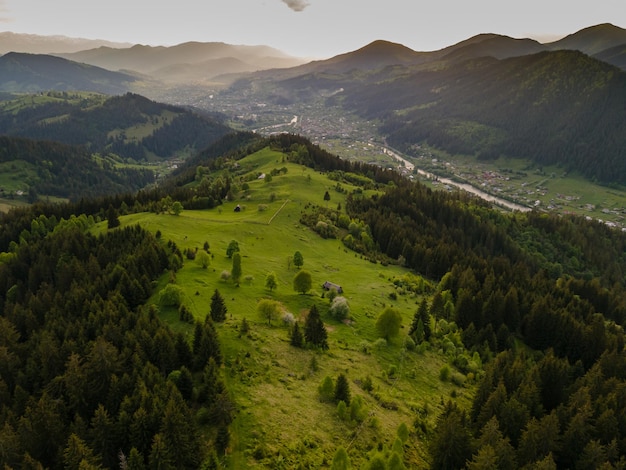 Pueblo en el paisaje de las montañas de los Cárpatos con prados verdes casas con árboles de jardines