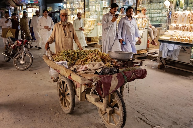 Pueblo paquistaní vistiendo ropas tradicionales en el mercado de Peshawar, Pakistán