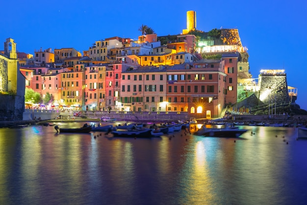 Pueblo de pescadores de noche Vernazza con torre de vigilancia del castillo de Doria para proteger el pueblo de los piratas, Cinco tierras, Parque Nacional de Cinque Terre, Liguria, Italia.