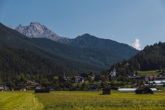 Pueblo en un prado de montaña. Prado verde y montañas