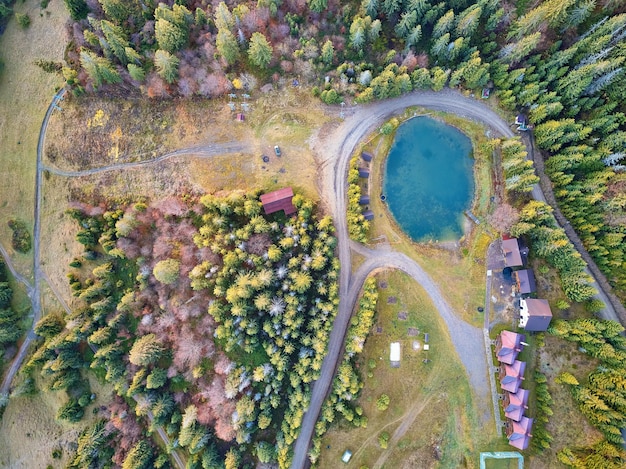 Pueblo turístico de montaña y hotel con estanque y bosque Vista aérea superior en el lago camino de tierra rural en el telesilla de madera Destino de viaje