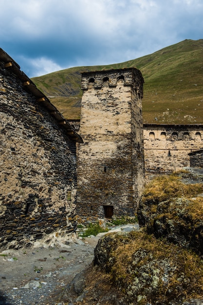 Pueblo Ushguli paisaje con enormes montañas rocosas pared Bezengi, Shkhara en el fondo en Svaneti, Georgia