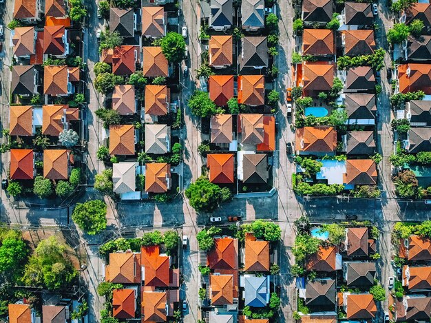 Pueblos con vista aérea superior con techos naranjas y jardines con naturaleza verde en las afueras de la ciudad