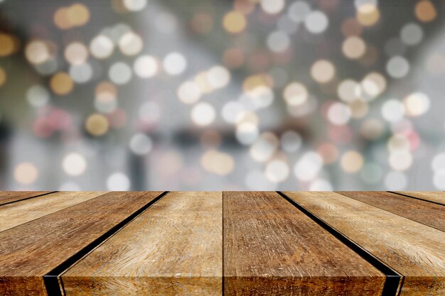 Se puede utilizar una mesa de madera vacía frente a un fondo bokeh borroso y abstracto para la exhibición