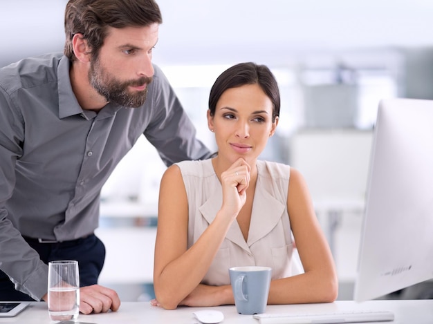 Foto puedo ver que has estado ocupado... dos hombres de negocios consultando entre sí sobre un proyecto.