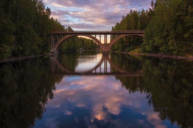 Puente de arco finlandés del antiguo ferrocarril sobre el río Janisjoki en Karelia al atardecer