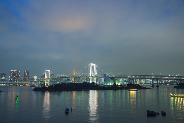 El puente arco iris en el crepúsculo en odaiba, Japón